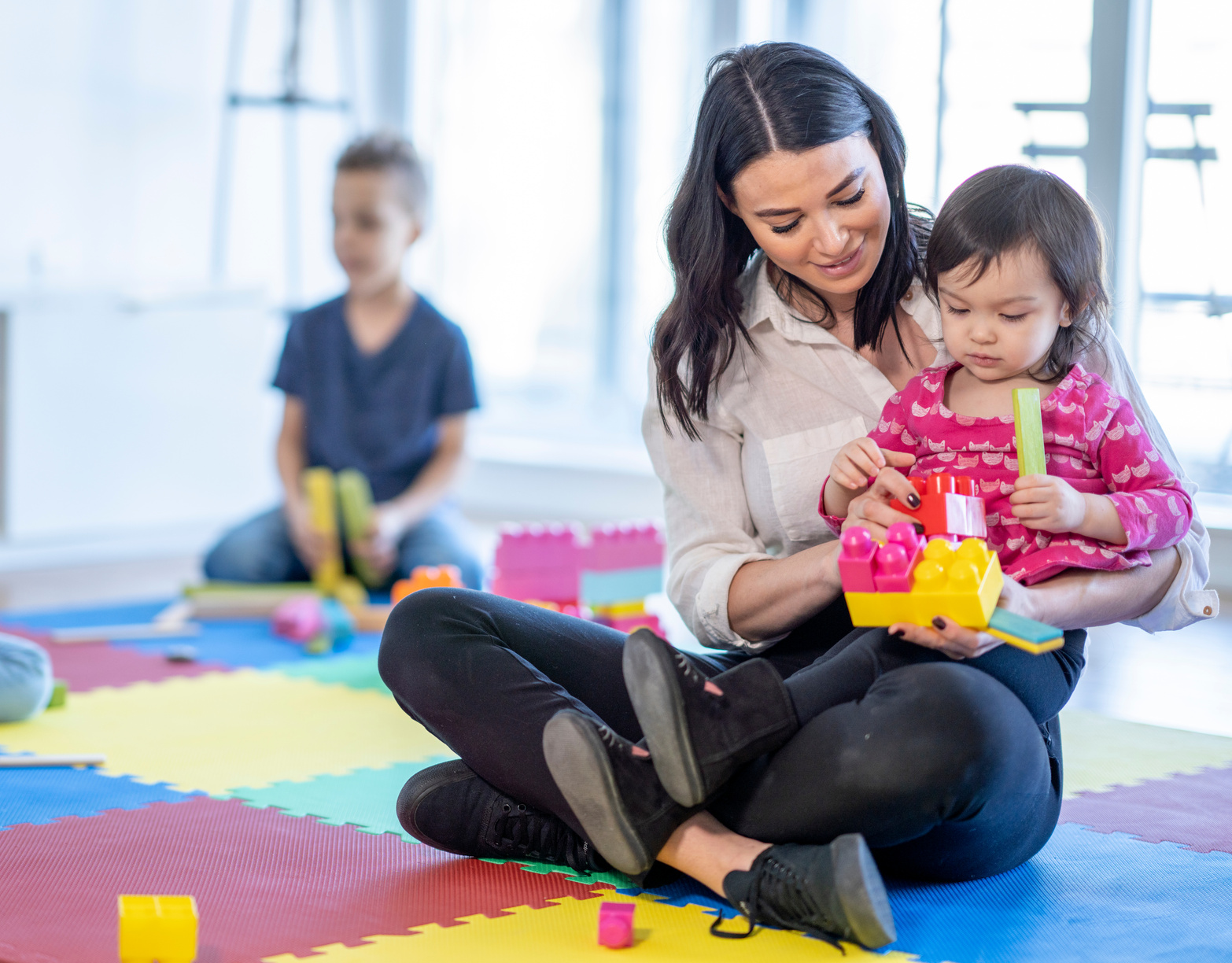 Childcare Provider Playing with Children stock photo